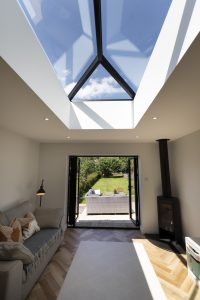 living room with wood burner and doors onto garden